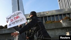 FILE - Police officers restrain a protester during a rally of journalists against a new media bill, in front of the Parliament building in Baku, Azerbaijan, Dec. 28, 2021. 