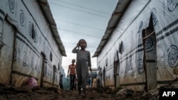 FILE - Internally displaced children walk through an alley of a camp in the town of Azezo, in Ethiopia's Amhara region, on July 12, 2021. The camp hosts Ethiopians as well as Eritrean refugees uprooted by the war in Tigray.