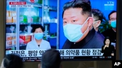 FILE - People watch a TV showing North Korean leader Kim Jong Un, at a train station in Seoul, South Korea, on May 16, 2022. 