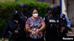 Oficiales de policía escoltan a la líder del cartel de drogas Herlinda Bobadilla luego de una solicitud de extradición para ella y sus hijos por parte de Estados Unidos, en Tegucigalpa, Honduras, 15 de mayo de 2022. REUTERS