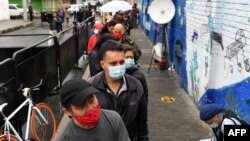 People queue at a polling station during the Colombian presidential election, in Bogota on May 29, 2022. 