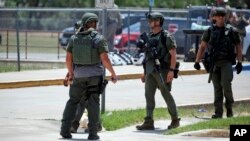 Law enforcement personnel stand outside Robb Elementary School following a shooting, May 24, 2022, in Uvalde, Texas.