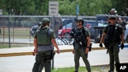 Law enforcement personnel stand outside Robb Elementary School following a shooting, May 24, 2022, in Uvalde, Texas.