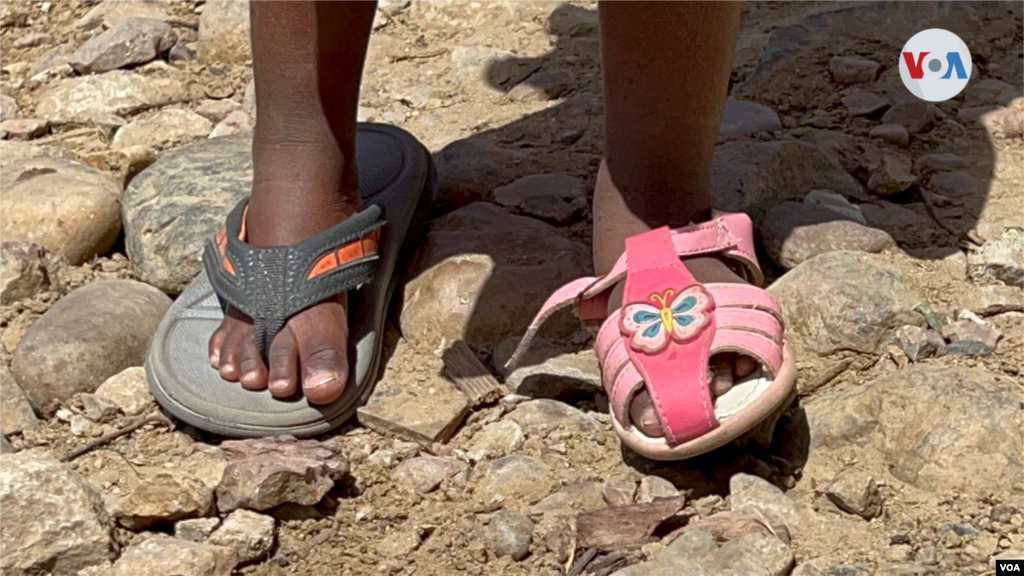 Una niña migrante haitiana, que vive en el Cañón del Alacrán, &nbsp;lleva puesta su sandalia en el pie izquierdo, y en el derecho una pantufla que no es de su talla. Foto: Celia Mendoza, 9 de abril de 2022. Tijuana México.