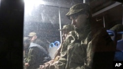 Ukrainian servicemen sit in a bus after they left Mariupol's besieged Azovstal steel plant, near a penal colony in Olyonivka, in territory under the government of the Donetsk People's Republic, eastern Ukraine, May 20, 2022.