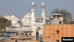 FILE - A worker stands on a temple rooftop adjacent to the Gyanvapi Mosque in the northern city of Varanasi, India, December 12, 2021. (REUTERS/Pawan Kumar/File Photo)