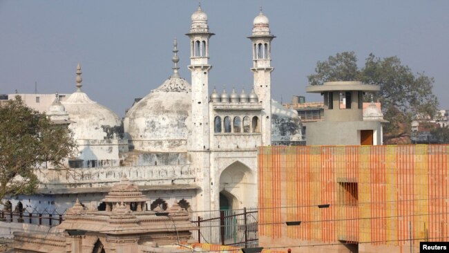 FILE - A worker stands on a temple rooftop adjacent to the Gyanvapi Mosque in the northern city of Varanasi, India, December 12, 2021. (REUTERS/Pawan Kumar/File Photo)