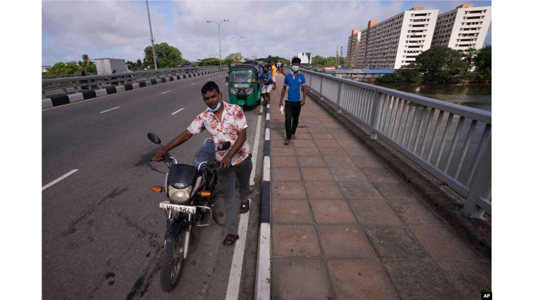 Para pengendara antre di luar SPBU untuk membeli bensin di Kolombo, Sri Lanka, Jumat, 20 Mei 2022. (AP Photo/Eranga Jayawardena)