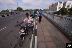 Para pengendara antre di luar SPBU untuk membeli bensin di Kolombo, Sri Lanka, Jumat, 20 Mei 2022. (AP Photo/Eranga Jayawardena)