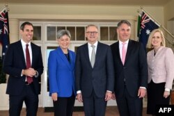 2022年5月23日澳大利亞新任總理安東尼·阿爾巴尼斯(中)在堪培拉政府大樓宣誓後與新任內閣部長吉姆·查默斯(左)、新任外長黃英賢(左二)、新任副總理理查德·馬爾斯和新任財政部長凱蒂·加拉格爾(右)合影留念。