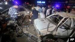 Penyelidik Pakistan memeriksa lokasi ledakan bom, di Karachi, Pakistan, pada 12 Mei 2022. Dua pelaku bom bunuh diri menyerang sebuah van yang membawa lima pekerja otomotif Jepang, tetapi mereka semua lolos tanpa cedera pada Jumat (19/4) .(Foto: AP)