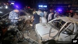 Pakistani investigators examine the site of bomb explosion, in Karachi, Pakistan, on May 12, 2022.