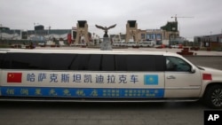 In this April 1, 2018, photo, a stretch limousine bearing Chinese and Kazakhstan flags is displayed in the special trade zone along Kazakhstan's border with China near Khorgos.