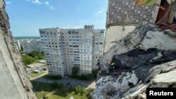 Rescuers work at a residential building damaged by shelling in the past, as Russia's attack on Ukraine continues, in Kharkiv, Ukraine, May 31, 2022.