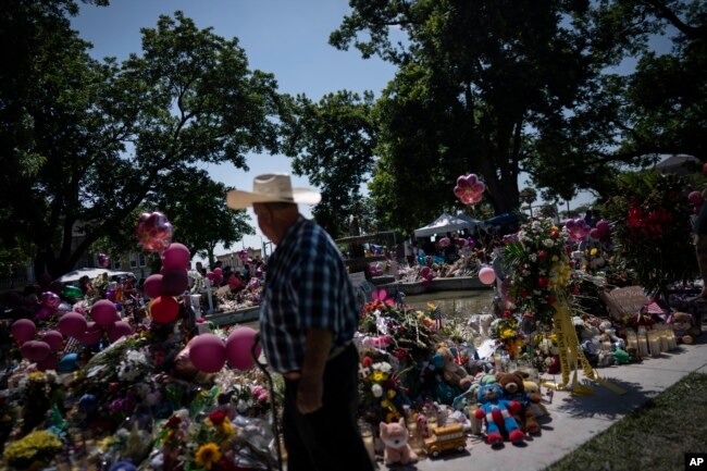 Flowers, balloons and soft toys overflow a memorial site in the town square of Uvalde set up for those killed in the mass shooting at Robb Elementary School, in Uvalde, Texas, May 29, 2022.
