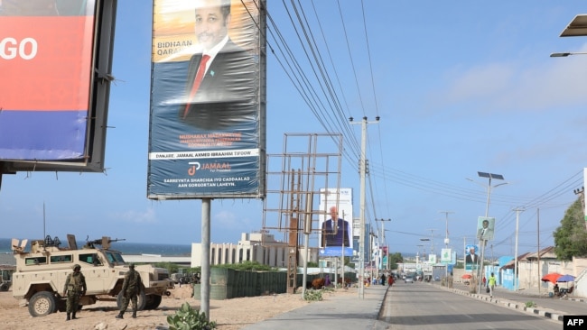 African Union peacekeepers stand next to election banners of presidential candidates along a street in Mogadishu, Somalia, May 13, 2022.</p> <p>