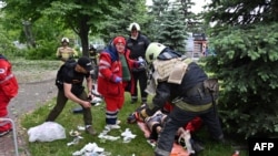Paramedics and emergency workers provide medical care to a man wounded as a result of shelling in Kharkiv, May 26, 2022, on the 91st day of Russia's invasion of Ukraine.