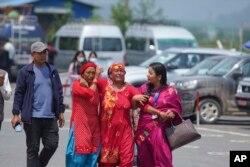 Kerabat penumpang pesawat Twin Otter turboprop Tara Air yang hilang meratap di luar bandara di Pokhara, Nepal, Minggu, 29 Mei 2022. (Foto: AP)