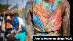 Senegalese photographer Ousmane Ndiaye Dago "paints" a model on May 21, 2022, as part of the Dakar Biennale.
