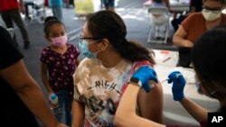 Seorang remaja sedang menerima vaksin COVID-19 di sebuah klinik di Orange, California, 28 Agustus 2021. (Foto: Jae C. Hong/AP Photo)