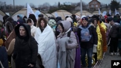 Des réfugiés ukrainiens attendent au poste frontière de Medyka, en Pologne, le 7 mars 2022.