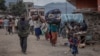 FILE - People attempt to cross the Democratic Republic of Congo and Ugandan border with their belongings to seek refuge after clashes between the Congolese army and the M23, in Bunagana, 100 kilometers from the city of Goma in eastern DRC, on April 2, 202