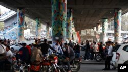 Dozens of Syrians wait at the President's Bridge in Damascus for relatives they hope would be among those released from prison on May 3, 2022.