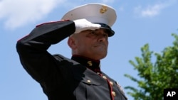 El Sargento del Cuerpo de Infantería de Marina de EEUU Tim Chambers saluda a los participantes en el evento "Rolling to Remember", durante el desfile anual de motocicletas, antes del Día de los Caídos, en Washington, el domingo 29 de mayo de 2022. 