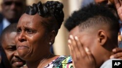 Tirzah Patterson, former wife of Buffalo shooting victim Heyward Patterson, speaks as her son, Jaques 'Jake' Patterson, 12, covers his face during a press conference outside the Antioch Baptist Church on May 19, 2022, in Buffalo, NY.