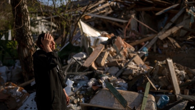 Anna Shevchenko, 35, reacts next to her house in Irpin, near Kyiv, on Tuesday, May 3, 2022. (AP Photo/Emilio Morenatti)