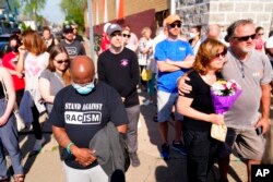 People gather outside the scene of a shooting at a supermarket in Buffalo, N.Y., May 15, 2022.