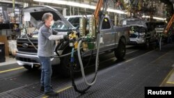 FILE - A Ford Motors assembly worker works on a Ford F-series pickup truck at the Dearborn Truck Plant in Dearborn, Michigan, Jan. 26, 2022. 