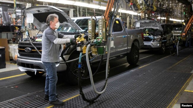 FILE - A Ford Motors assembly worker works on a Ford F-series pickup truck at the Dearborn Truck Plant in Dearborn, Michigan, Jan. 26, 2022.