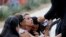 A woman reacts as a priest comforts people outside the Ssgt. Willie de Leon Civic Center, where students had been transported from Robb Elementary School after a shooting, in Uvalde, Texas, May 24, 2022.