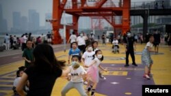 Anak-anak bermain di taman tepi sungai, setelah pencabutan lockdown di Shanghai, China, 1 Juni 2022. (Foto: Reuters)