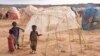 FILE - Children stand next to a makeshift shelter at the Higlo camp for people displaced by drought, in the town of Gode, in Ethiopia's Somali region, April 27, 2022. 