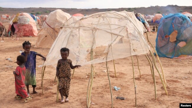 FILE - Children stand next to a makeshift shelter at the Higlo camp for people displaced by drought, in the town of Gode, in Ethiopia's Somali region, April 27, 2022.