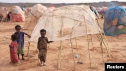 FILE - Children stand next to a makeshift shelter at the Higlo camp for people displaced by drought, in the town of Gode, in Ethiopia's Somali region, April 27, 2022. 