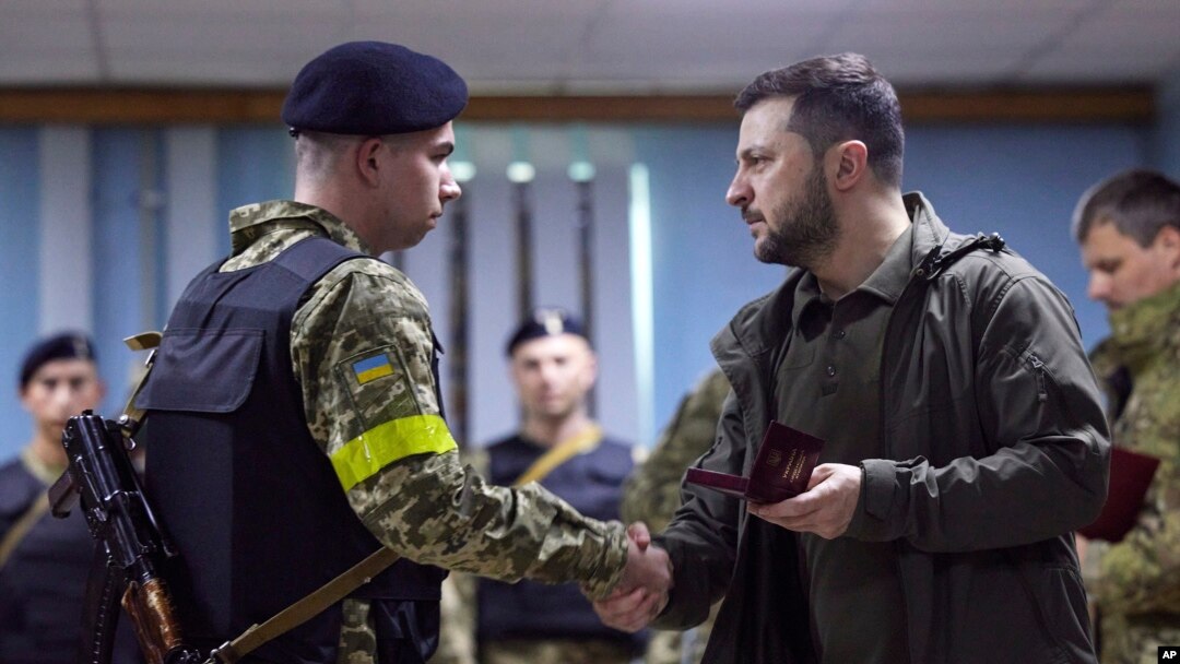 Presiden Ukraina Volodymyr Zelenskyy, kanan, memberikan penghargaan kepada seorang prajurit saat ia mengunjungi wilayah Kharkiv yang dilanda perang. (Foto: via AP)