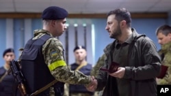 2022年5月29日，乌克兰总统泽连斯基在视察哈尔科夫地区时为一名乌克兰军人授勋。泽连斯基在周六发布的视频中表示，乌东地区的形式目前“越来越困难”。俄军试图通过对该地区的集中攻击来获取一些成果。（照片由乌克兰总统办公室通过美联社提供）