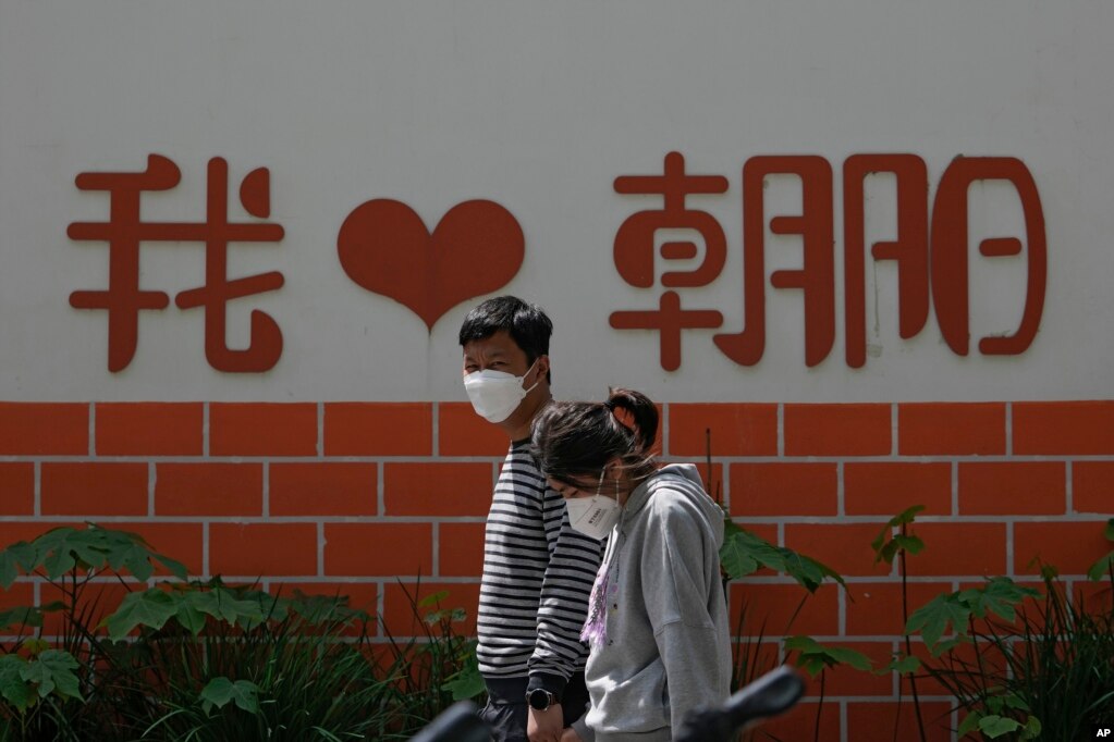 北京朝阳区两个带着口罩的居民去排队做新冠核酸检测。（2022年5月11日）(photo:VOA)