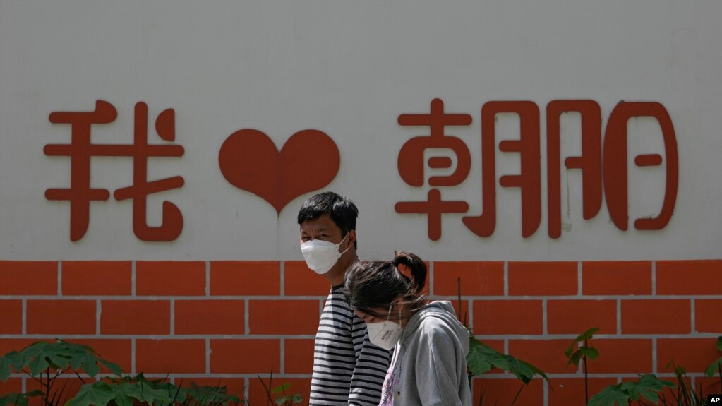 北京朝阳区两个带着口罩的居民去排队做新冠核酸检测。（2022年5月11日）(photo:VOA)