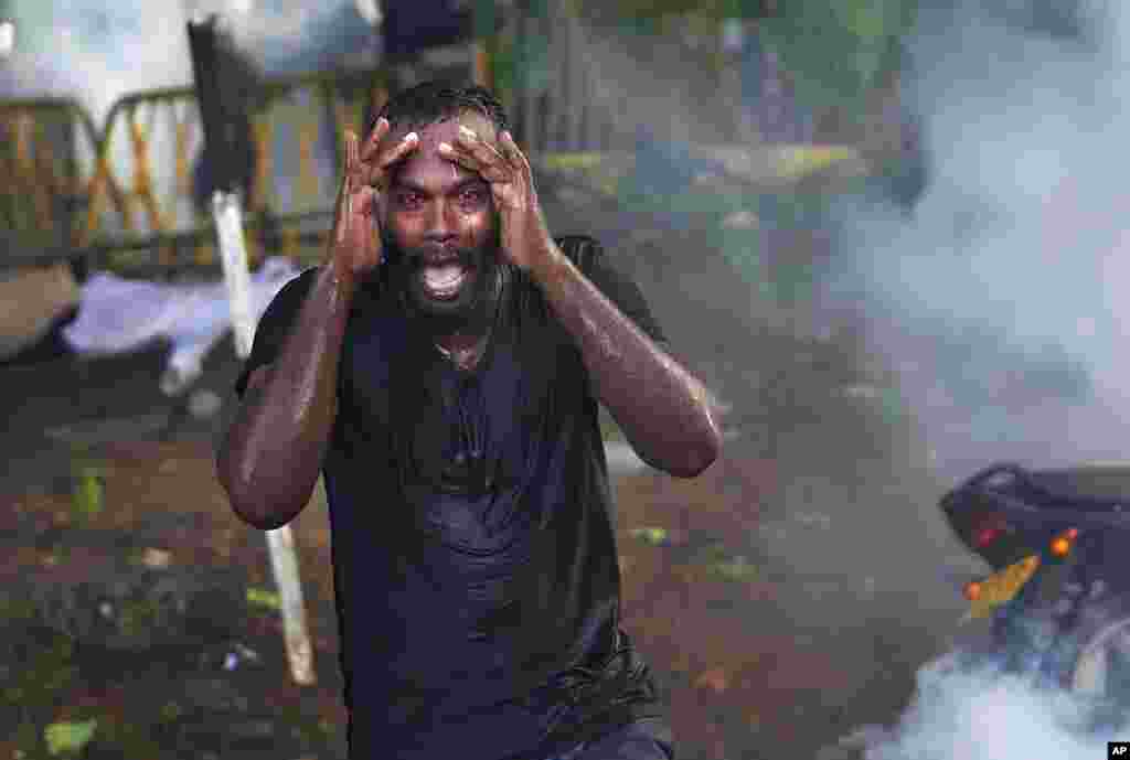 An injured protester grieves in pain as police fire tear gas to disperse protesting members of the Inter University Students Federation during an anti-government protest in Colombo, Sri Lanka. &nbsp;