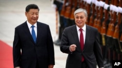 2019 年 9 月 11 日，中国国家主席习近平（左）和哈萨克斯坦总统卡瑟姆若马尔特·托卡耶夫在北京人民大会堂举行的欢迎仪式上检阅仪仗队。
