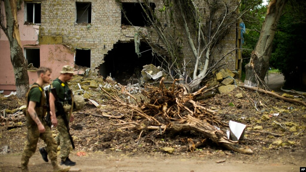 卢甘斯克州乌克兰控制的最后两座城市利西昌斯克和北顿涅茨克遭到俄军猛烈进攻，乌克兰军人走过利西昌斯克一座被俄军严重炸坏的建筑。(2022年5月28日)(photo:VOA)