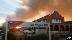 A sunset is seen through a wall of wildfire smoke from the Amtrak train station in Las Vegas, New Mexico, May 7, 2022.