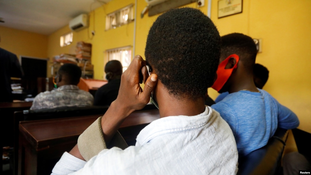  File - Men charged with public displays of affection with members of the same sex sit inside a court in Lagos, Nigeria Oct. 27, 2020.
