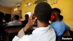  File - Men charged with public displays of affection with members of the same sex sit inside a court in Lagos, Nigeria Oct. 27, 2020.