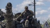 乌克兰顿涅茨克地区的一名乌军士兵坐在坦克车顶上。（2022年5月25日）