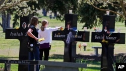 FILE: A family visits the memorial crosses dedicated to 13 people killed in the 1999 Columbine High School shooting, in Littleton, Colo., April 20, 2014.